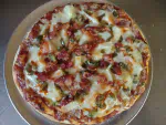 The Twin Bay Resort Hot Lei Pizza, Canadian Bacon, Pinapple, Diced Jalapeno, Crumbled Bacon, & a drizzle of Hot Sauce.